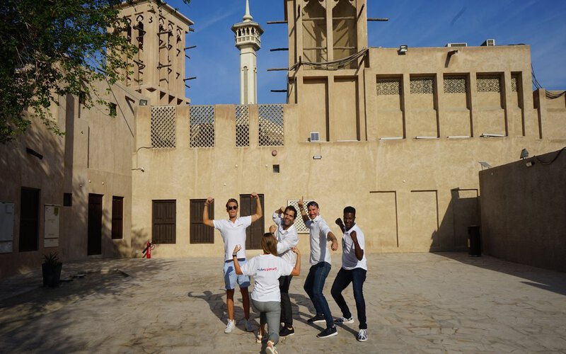 A team celebrating in the old Al Fahidi district, by the Creek