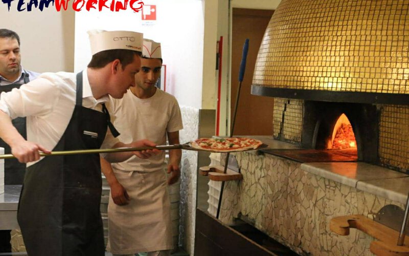A team making pizza with a master pizzaiolo, from the dough to the oven