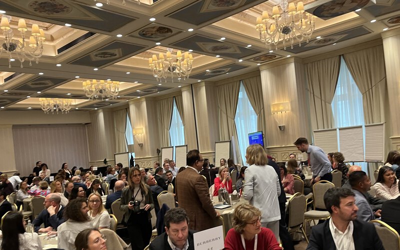 A hall full of teams working on the app challenges at their tables
