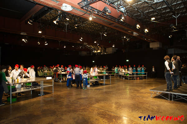 A big room set up with cooking stations for the whole company