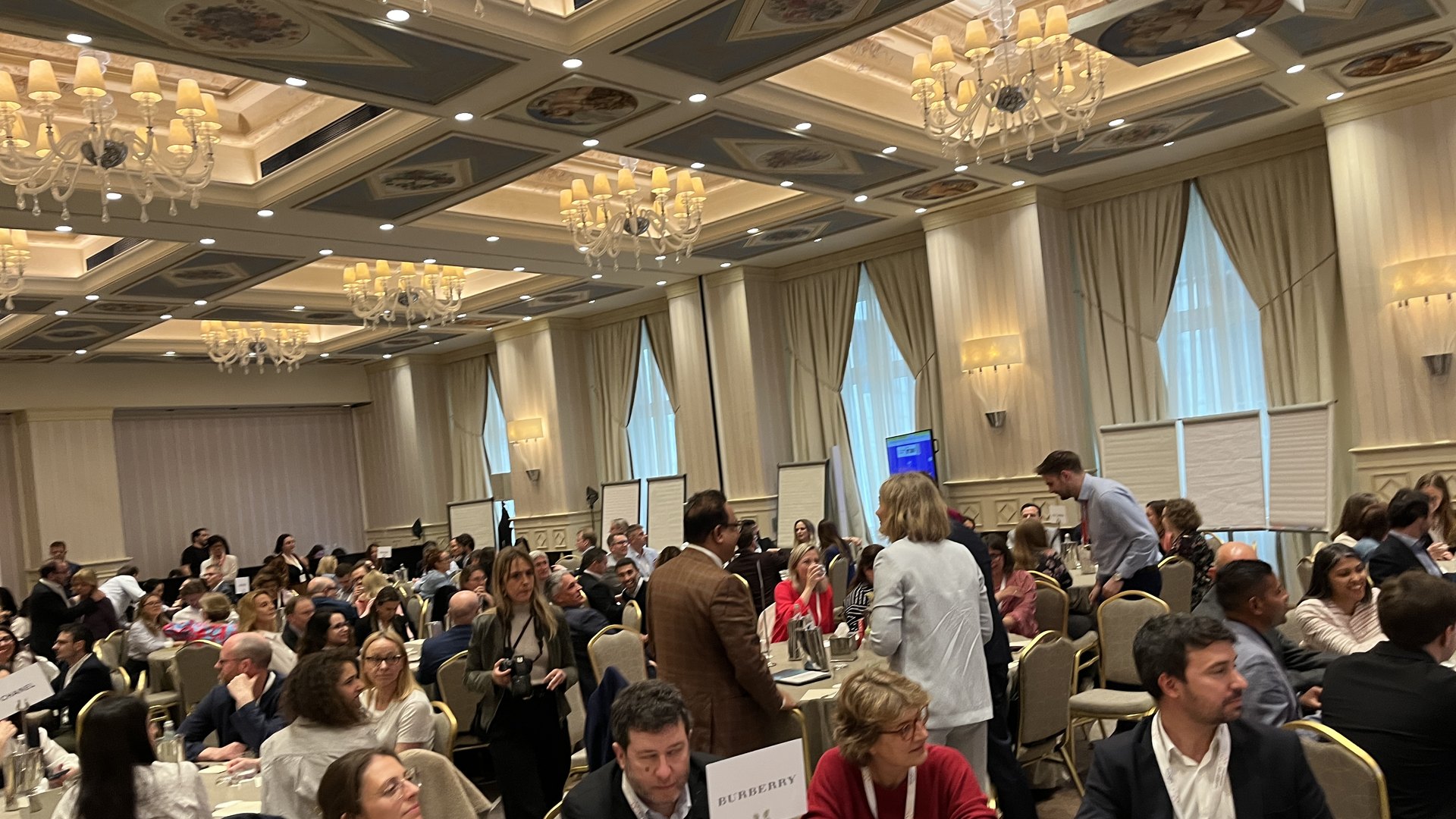 A ballroom full of teams working at round tables during a Sparkathlon
